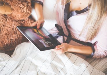 Girl Holding an iPad in Bed