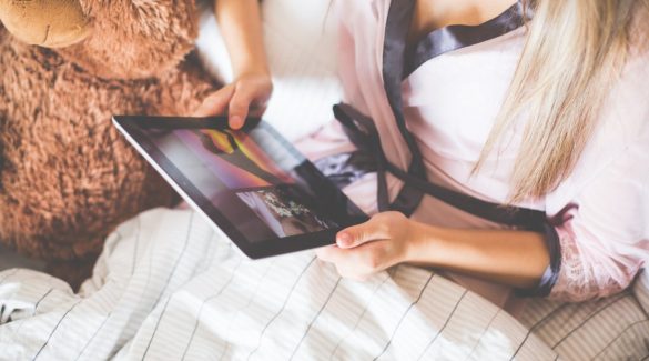 Girl Holding an iPad in Bed